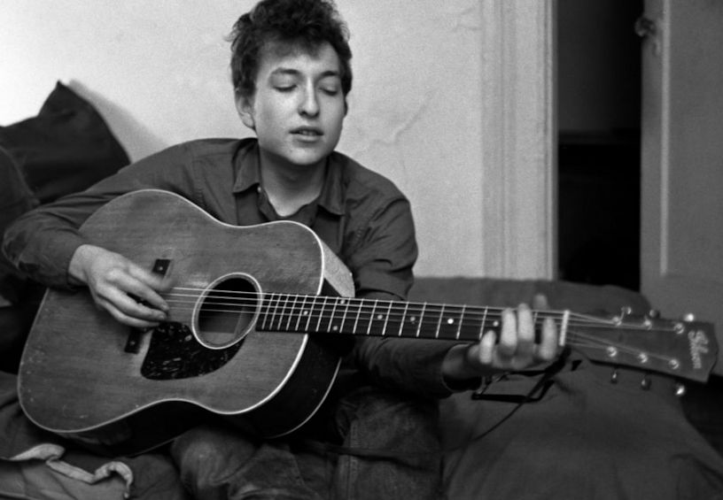 A young Bob Dylan playing guitar.