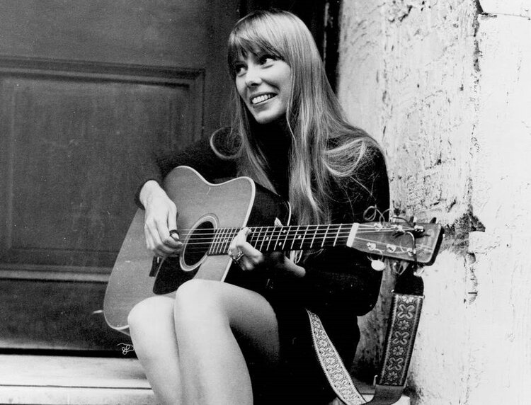 Young Joni Mitchell with wooden guitar. She is not only a great singer-songwriter, but also a superb guitar master.